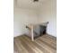 Bright stairwell with wood flooring and black iron railing descends to lower level at 82 Cool Creek Dr, Willow Springs, NC 27592