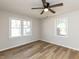 Bright bedroom featuring light-colored walls, hardwood flooring, and dual windows with natural light at 823 Elmira Ave, Durham, NC 27707
