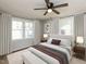 Staged bedroom with a modern ceiling fan, lots of light from dual windows, and plush carpet at 823 Elmira Ave, Durham, NC 27707