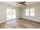 A bright bedroom offers sliding glass doors with backyard views, wood-look flooring, and plenty of natural light at 823 Elmira Ave, Durham, NC 27707