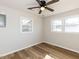 Bedroom with two windows, modern fan and wood look flooring at 823 Elmira Ave, Durham, NC 27707