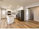 This modern kitchen has white cabinetry, stainless steel appliances, a kitchen island, and wood-look floors at 823 Elmira Ave, Durham, NC 27707