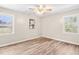 Bright bedroom with two windows, neutral walls, wood-look floors, and a ceiling fan at 8412 Pierce Olive Rd, Apex, NC 27539