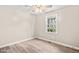 Simple bedroom featuring a window, wood-look flooring, and neutral walls at 8412 Pierce Olive Rd, Apex, NC 27539