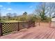 Spacious wood deck with decorative lattice railing and a view of the expansive backyard on a sunny day at 8412 Pierce Olive Rd, Apex, NC 27539