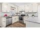 Well-lit kitchen featuring stainless steel appliances, granite countertops, and white cabinets at 8412 Pierce Olive Rd, Apex, NC 27539
