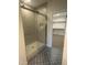 Tile shower with glass door and walk-in closet with shelving, all with decorative tile floor at 9231 Bear Run Ln, Middlesex, NC 27557