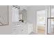 Bright bathroom featuring double vanity with marble counters, a large mirror, and patterned tile flooring at 9231 Bear Run Ln, Middlesex, NC 27557