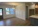 Open-concept view of dining area featuring modern light fixture and view into kitchen with light wood floors at 9231 Bear Run Ln, Middlesex, NC 27557