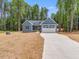 Home's charming exterior with an attached garage and long driveway at 9231 Bear Run Ln, Middlesex, NC 27557