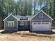 New construction home showing charming curb appeal with board and batten siding and two car garage at 9231 Bear Run Ln, Middlesex, NC 27557