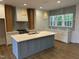 Bright and modern kitchen features a large island, custom cabinetry, and stainless-steel appliances at 9231 Bear Run Ln, Middlesex, NC 27557