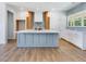 Bright kitchen boasts a large island, stainless appliances, and wood floors at 9231 Bear Run Ln, Middlesex, NC 27557