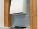 Modern kitchen featuring sleek white range hood, wood cabinets and gray tile backsplash at 9231 Bear Run Ln, Middlesex, NC 27557