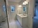 Well-lit bathroom with double sinks, large mirror, and modern fixtures, adjacent to a walk-in shower at 9235 Bear Run Ln, Middlesex, NC 27557