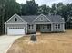 Charming new home boasts a manicured lawn, double-door entryway, and an attached two-car garage at 9235 Bear Run Ln, Middlesex, NC 27557