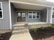 Inviting front porch features a double-door entryway, brick steps, and stylish, neutral-toned siding at 9235 Bear Run Ln, Middlesex, NC 27557