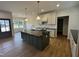 Modern kitchen with dark island, light countertops and cabinets, pendant lighting and hardwood floors at 9235 Bear Run Ln, Middlesex, NC 27557