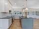 Bright kitchen featuring white cabinets, a central island, and stainless steel appliances at 9235 Bear Run Ln, Middlesex, NC 27557
