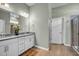 Bathroom featuring a double vanity with white cabinets and a large mirror at 1 Parker Pond Ct, Durham, NC 27703