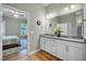 Bathroom featuring a double vanity with white cabinets and access to the main bedroom at 1 Parker Pond Ct, Durham, NC 27703