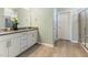 Well-lit bathroom featuring a double vanity, neutral-toned tile flooring, and glass door shower at 1 Parker Pond Ct, Durham, NC 27703