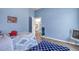 bedroom with blue walls, a patterned rug, and a view into the foyer at 1 Parker Pond Ct, Durham, NC 27703