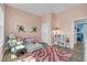 Bright ' room with a pink zebra rug, play kitchen, a twin sized bed with stuffed animals, and light hardwood floors at 1 Parker Pond Ct, Durham, NC 27703