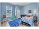 bedroom with blue walls, a patterned rug, and a window with natural light at 1 Parker Pond Ct, Durham, NC 27703