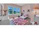 Bright bedroom with pink accents, a comfortable bed, and large windows offering natural light at 1 Parker Pond Ct, Durham, NC 27703