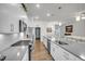 Modern kitchen featuring stainless appliances, white cabinetry, a center island with a sink, and modern lighting at 1 Parker Pond Ct, Durham, NC 27703