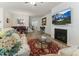 Open-concept living room and dining area with a fireplace, large TV, plush seating, and a beautiful rug at 1 Parker Pond Ct, Durham, NC 27703