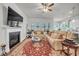 Spacious living room featuring hardwood floors, a fireplace, a ceiling fan, modern lighting and comfortable seating at 1 Parker Pond Ct, Durham, NC 27703