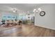 Open-concept living room and kitchen boasting hardwood floors, modern lighting, stainless appliances, and comfortable seating at 1 Parker Pond Ct, Durham, NC 27703