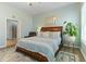 The primary bedroom boasts soothing paint, hardwood floors and a comfortable king bed and en-suite bath at 1 Parker Pond Ct, Durham, NC 27703