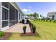 Cozy screened porch with paver patio, grill, and manicured landscaping at 1 Parker Pond Ct, Durham, NC 27703