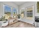Bright sunroom with three large windows, light wood floors, decor, and a drink station at 1 Parker Pond Ct, Durham, NC 27703