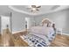 Spacious bedroom with a tray ceiling, hardwood floors, neutral colors and natural light from two windows at 10 Holden Ct, Youngsville, NC 27596