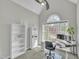 Bright office space featuring a large arched window, built-in storage, and space for a work area at 10 Holden Ct, Youngsville, NC 27596