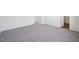 A gray carpeted bedroom with a doorway to a bathroom and lots of natural light at 103 Gabriel Ct, Clayton, NC 27520
