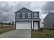 Charming two-story home with a white garage door, white trimmed windows, and a landscaped front yard at 103 Gabriel Ct, Clayton, NC 27520