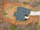 Aerial view of a fenced backyard with a playset and a modern home with black roof at 105 Shawnee Drive, Louisburg, NC 27549