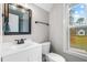 Bathroom with a white vanity, wood-framed mirror, and a window at 105 Shawnee Drive, Louisburg, NC 27549