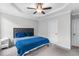 Cozy bedroom features a tray ceiling, ceiling fan, white trim and gray headboard at 105 Shawnee Drive, Louisburg, NC 27549