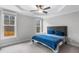 Bright carpeted bedroom features a gray headboard, tray ceiling and ceiling fan at 105 Shawnee Drive, Louisburg, NC 27549