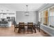 Bright dining area with wood floors, modern lighting fixture, and kitchen in the background at 105 Shawnee Drive, Louisburg, NC 27549