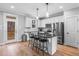 Kitchen features white cabinets, dark countertops, island with seating, and stainless steel appliances at 105 Shawnee Drive, Louisburg, NC 27549