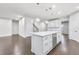 Bright kitchen featuring a large island with seating and sleek stainless steel appliances, flowing into an open-concept living area at 1103 Freestone Rd, Durham, NC 27703