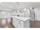 Open kitchen with an island, stainless steel dishwasher, and view to living room with fireplace and staircase at 1103 Freestone Rd, Durham, NC 27703