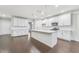 Spacious, modern kitchen with white cabinetry, a large island with seating, stainless steel appliances, and dark hardwood floors at 1103 Freestone Rd, Durham, NC 27703